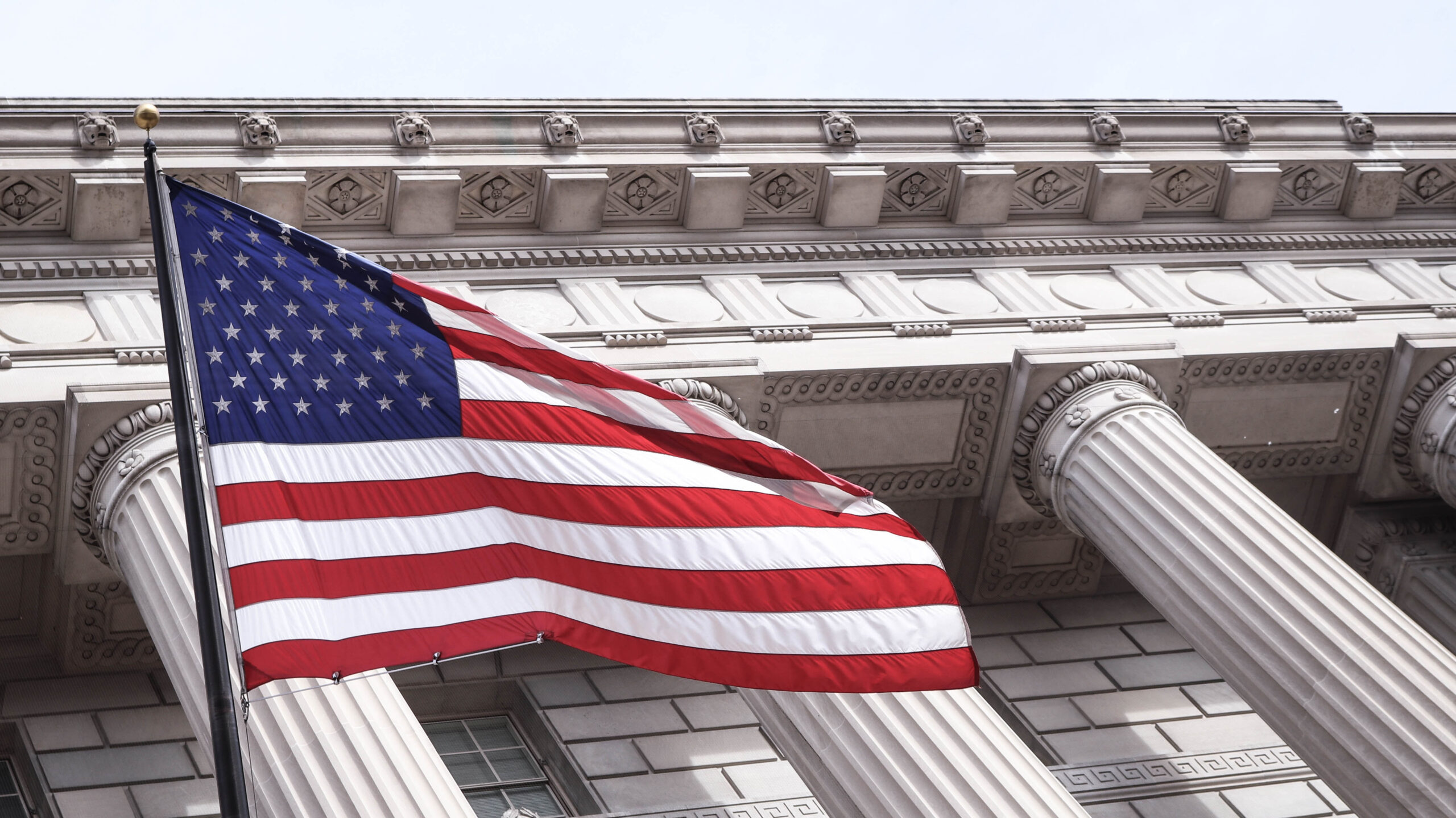 American flag in front of federal building with ornate columns