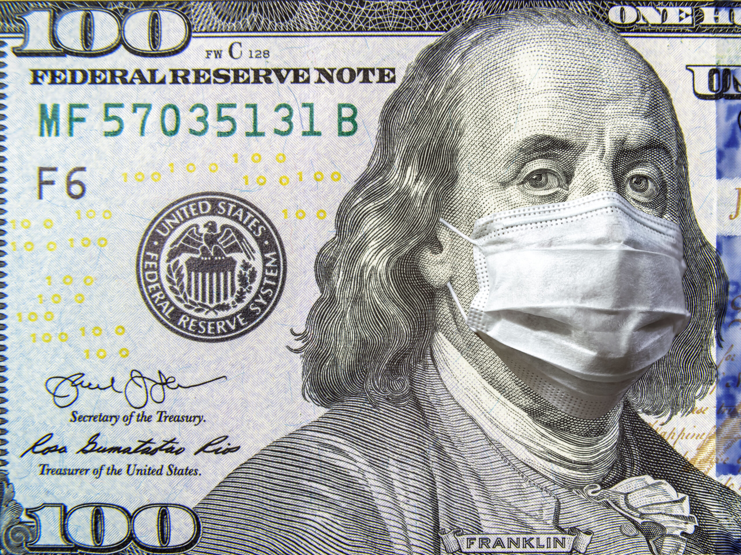 One hundred US Dollar bill with Benjamin Franklin wearing a surgical mask