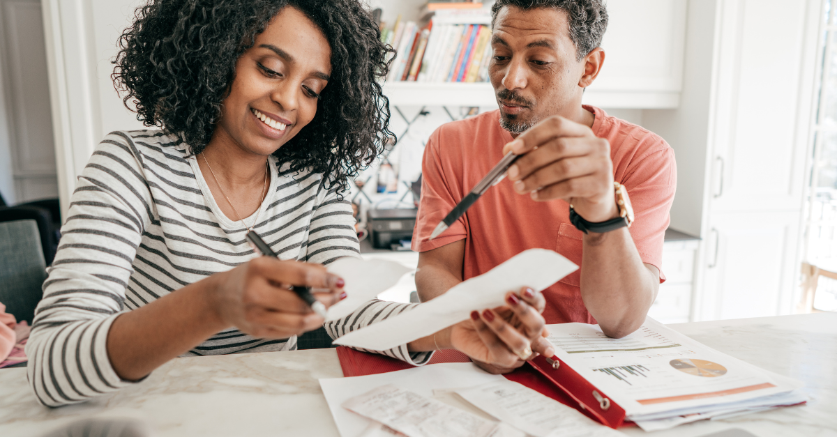 A couple sitting at a table looking at papers and receipts